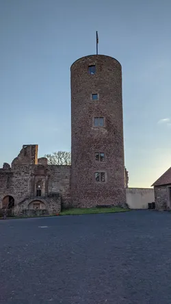 Der runde Bergfried der Burgruine Schwarzenfels im Abendlicht