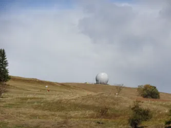 Das Radom auf der Kuppe der Wasserkuppe über den herbstlich braunen Bergwiesen