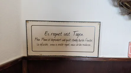 Blechschild an der Wand des Fuldaer Hauses mit dem Spruch „Es regnet seit Tagen …“