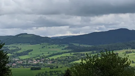 Weiter Blick vom Wachtküppel über Wiesen, Wälder und ein Dorf im Tal