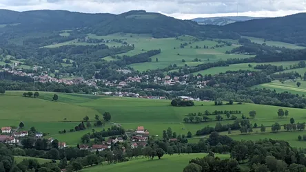 Weite Aussicht vom Wachtküppel über Wiesen, Höfe und einen Ort am Hang