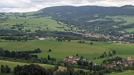 Blick vom Wachtküppel auf einen Ort im Tal, dahinter gestaffelte bewaldete Höhen