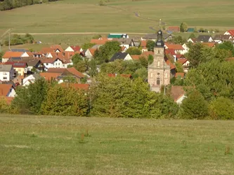 Seiferts im Tal mit seiner Barockkirche, davor Wiesen und Baumreihen