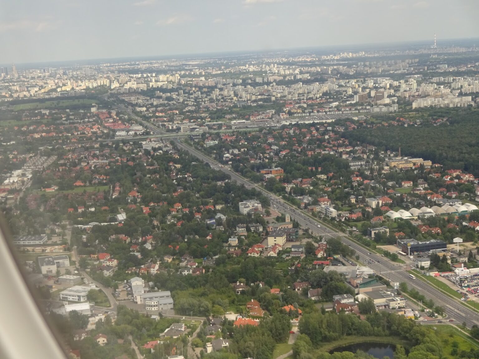 Blick aus dem Flugzeugfenster auf Sofia beim Anflug: Wohnviertel, eine breite Ausfallstraße und dahinter das flache Umland