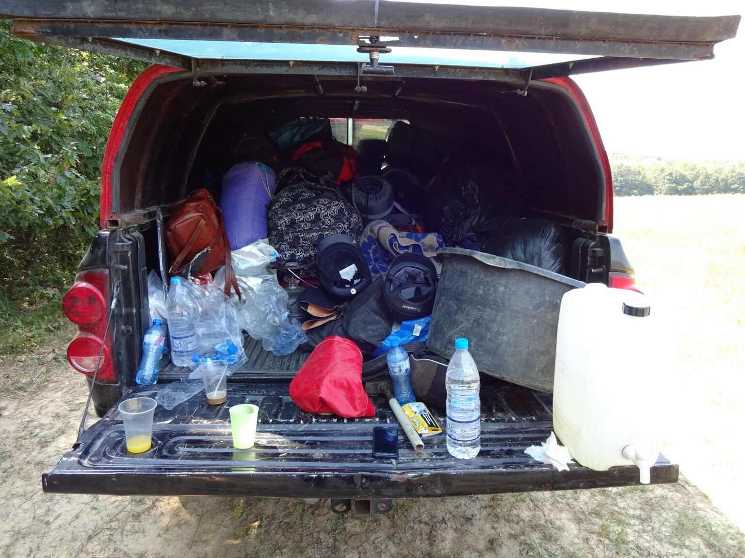 Vollgepackte Ladefläche des Begleitfahrzeugs mit Schlafsäcken, Taschen, Wasserkanister und Wasserflaschen