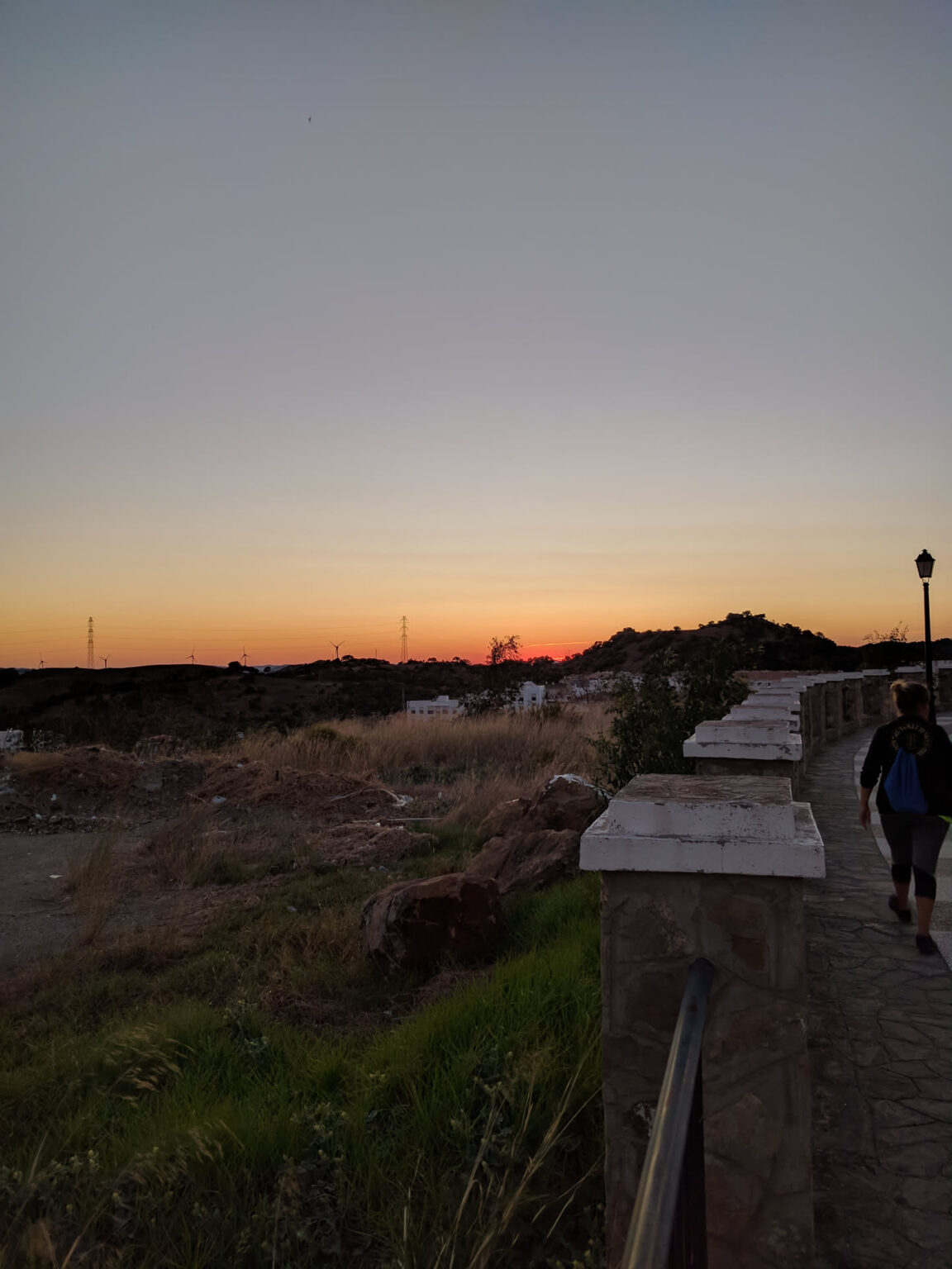 Sonnenuntergang über der weiten Ebene, von einer Aussichtsmauer in Alcalá de los Gazules aus gesehen